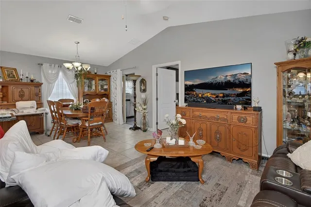 a living room with furniture a flat screen tv and kitchen view