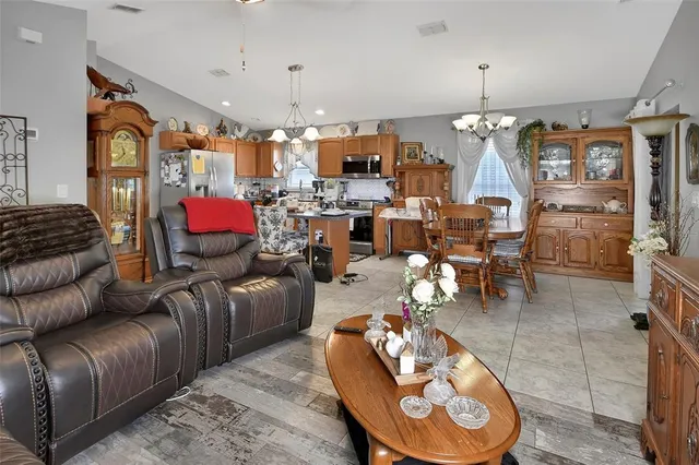 a living room with furniture kitchen and a chandelier