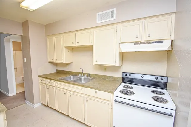 a kitchen with granite countertop cabinets stainless steel appliances and a sink