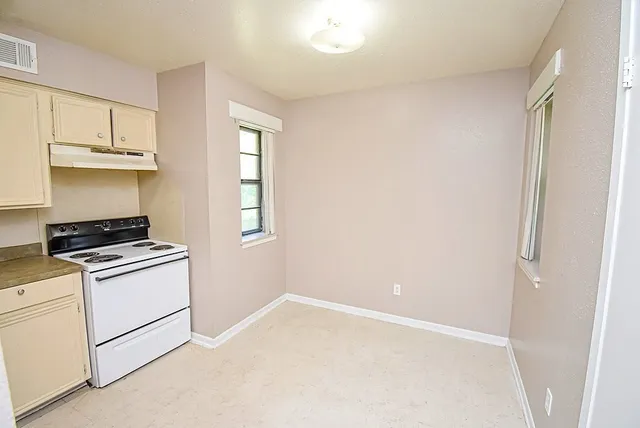 a kitchen with white cabinets and white appliances