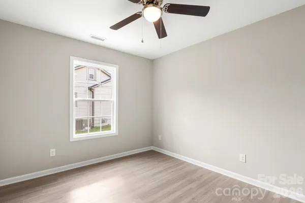 an empty room with windows and fan