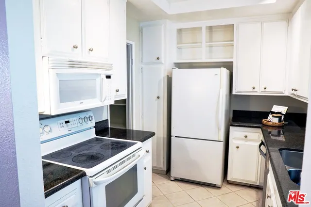 a kitchen with a refrigerator stove and white cabinets
