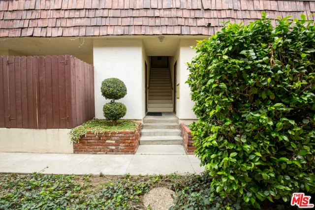 a front view of a house with plants