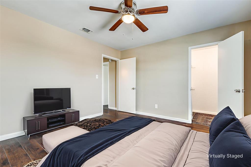 2200 East Trinity Mills Road, Unit 402 Carrollton, TX 75006 - Photo 11 of 12 a bedroom with a bed and a flat screen tv