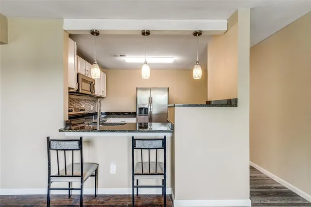 a kitchen with kitchen island a sink stove and refrigerator