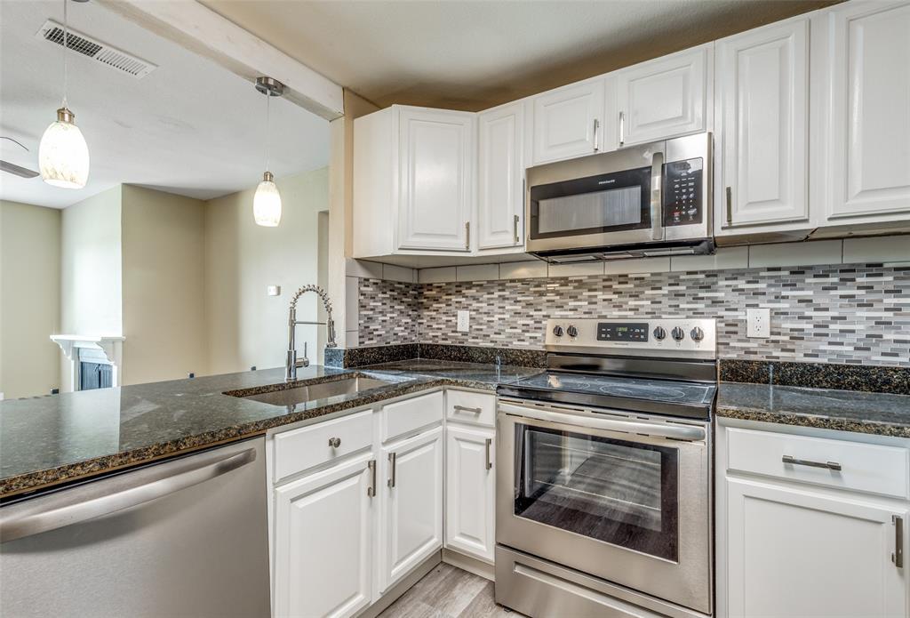 2200 East Trinity Mills Road, Unit 402 Carrollton, TX 75006 - Photo 5 of 12 a kitchen with granite countertop white cabinets stainless steel appliances and a sink