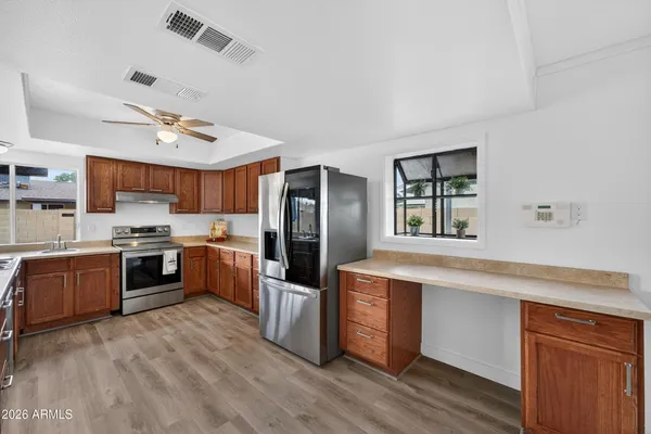 a large kitchen with stainless steel appliances granite countertop a stove refrigerator and a sink