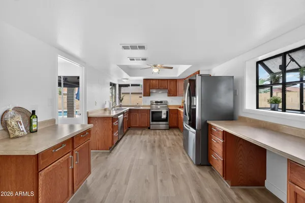 a large kitchen with stainless steel appliances kitchen island granite countertop a large counter top and wooden floors