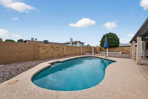 a view of a house with pool and chairs