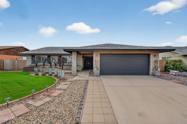 a front view of a house with a garden and patio