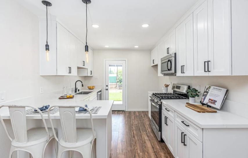 635 Paraiso Avenue Spring Valley, CA 91977 - Photo 20 of 27 a kitchen with stainless steel appliances granite countertop a sink a stove a refrigerator and white cabinets with wooden floor