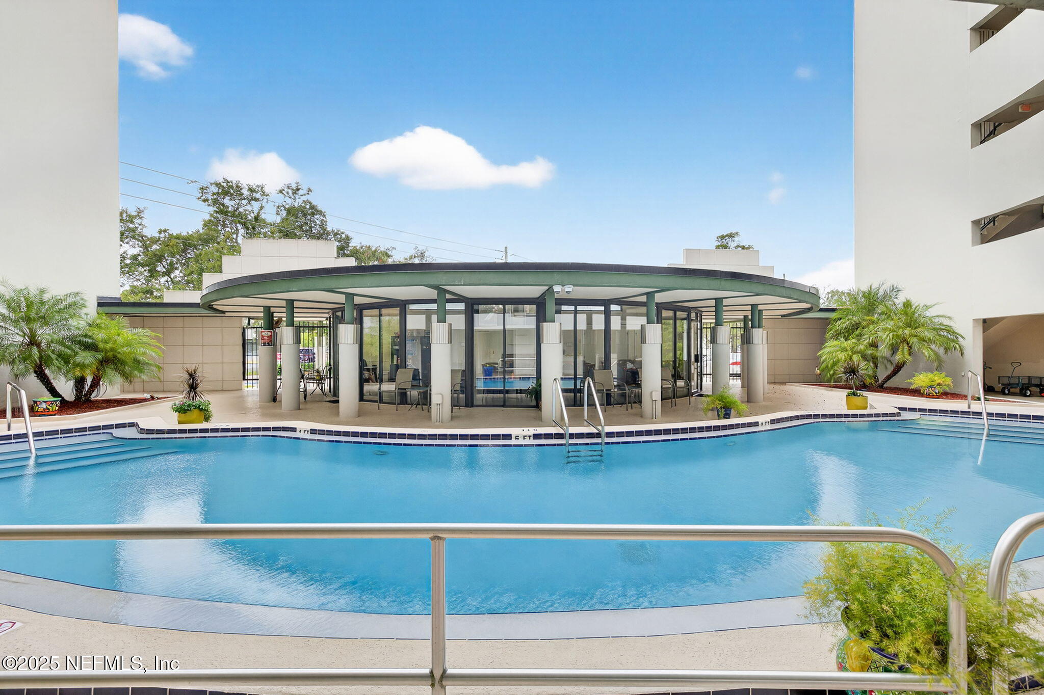 1071 Edgewood Avenue South, Unit 409 Jacksonville, FL 32205 - Photo 30 of 39 a view of a large pool with a dining table and chairs under an umbrella