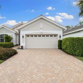 a view of a white house with a yard and potted plants