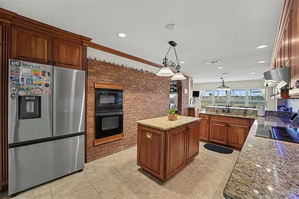 a kitchen with stainless steel appliances granite countertop a refrigerator a sink and a stove