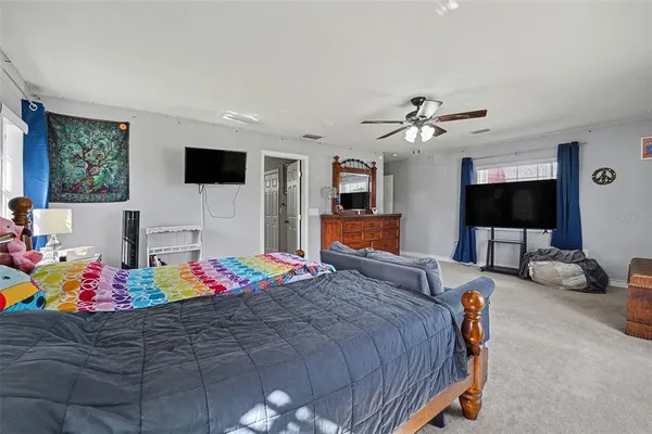 a bedroom with furniture and a flat screen tv