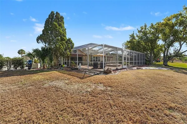 a view of large house with a yard and sitting area