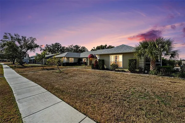 a front view of a house with a yard and trees