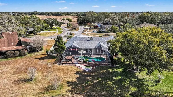 an aerial view of a house with a yard and lake view