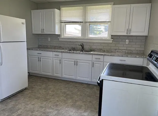 a kitchen with a sink cabinets and window