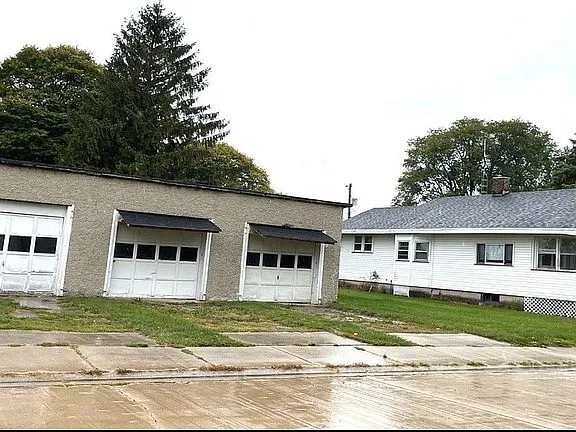 a view of a house with a garden and trees