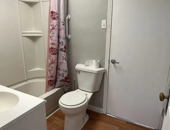 a white toilet sitting next to a bath tub