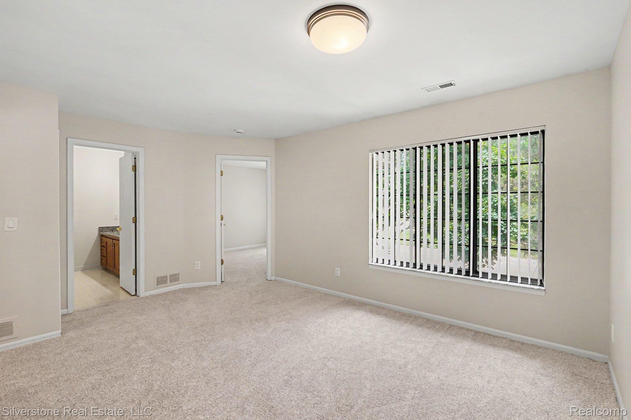 1502 Meadowside Drive Rochester, MI 48307 - Photo 16 of 27 Carpeted room with a large window featuring vertical blinds