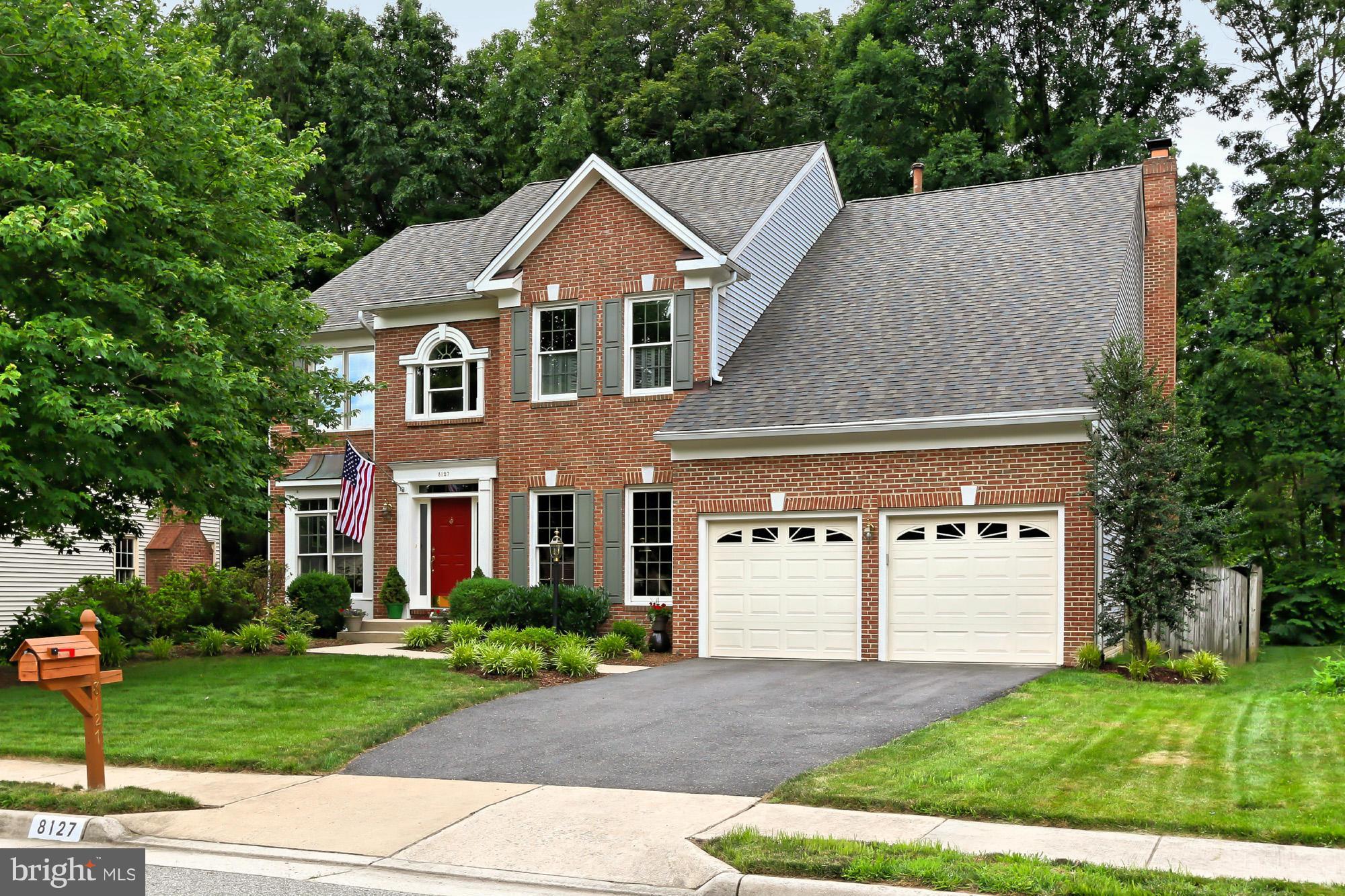 8127 Ridge Creek Way Springfield, VA 22153 - Photo 1 of 30 a front view of a house with a yard and garage