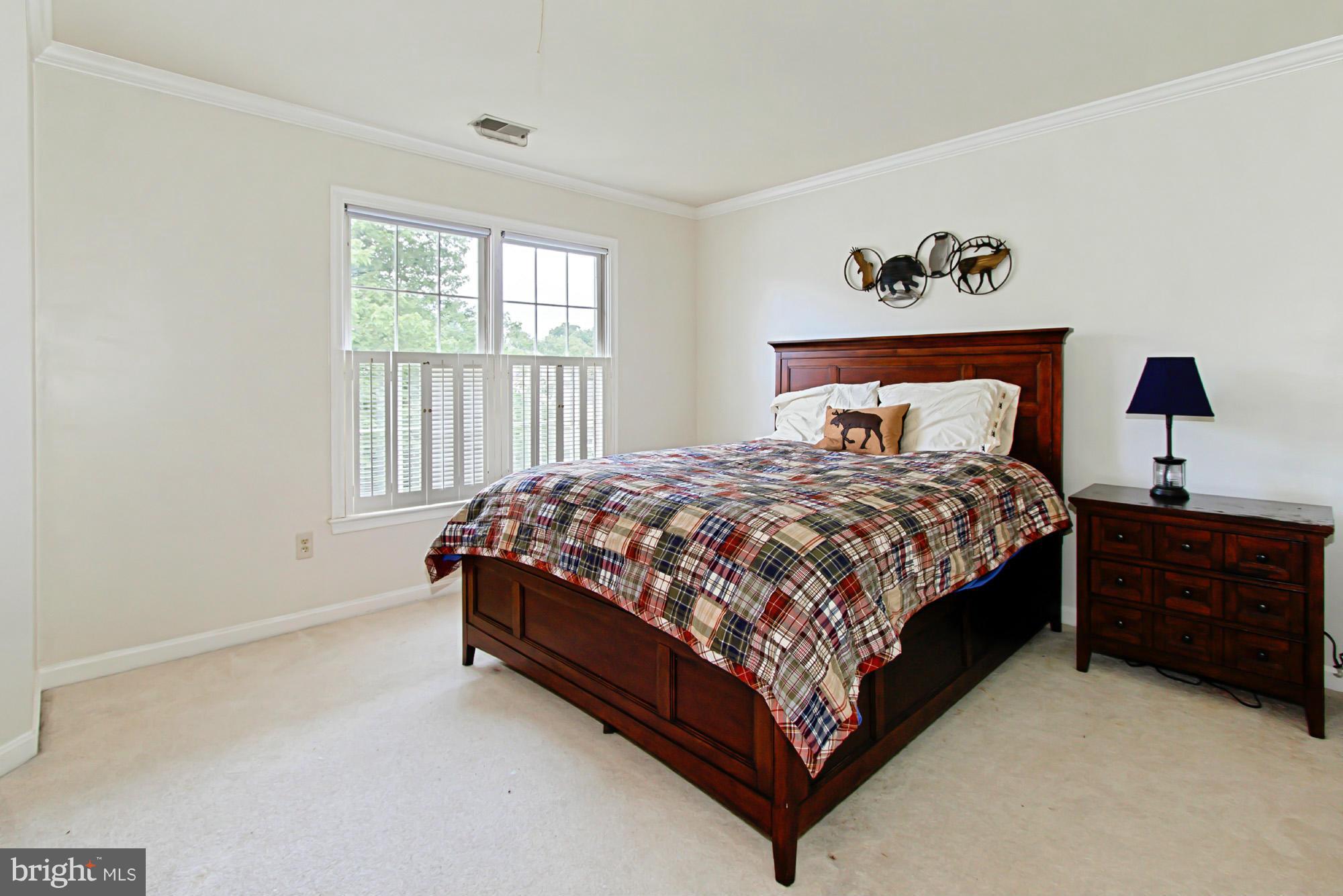 8127 Ridge Creek Way Springfield, VA 22153 - Photo 20 of 30 a bed sitting in a bedroom next to a window