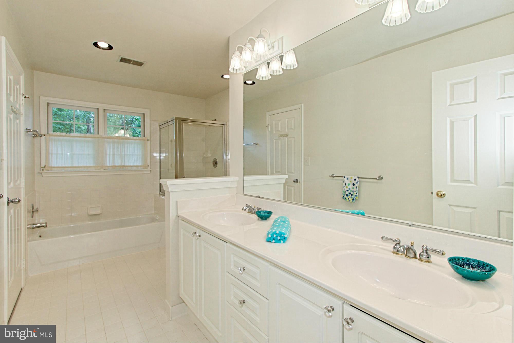 8127 Ridge Creek Way Springfield, VA 22153 - Photo 22 of 30 a bathroom with a sink a large mirror and shower