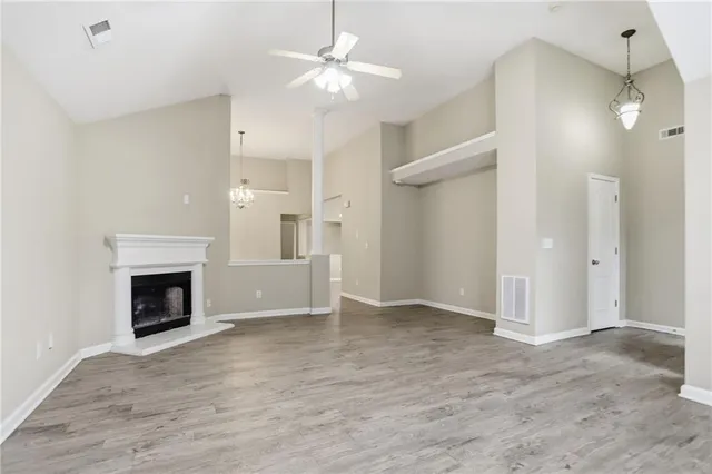 an empty room with fan and a fireplace