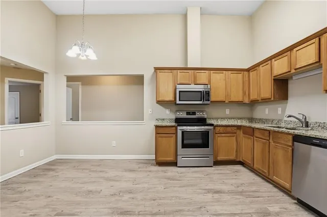 a kitchen with stainless steel appliances granite countertop a stove sink and microwave