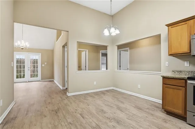 an empty room with windows fireplace and wooden floor