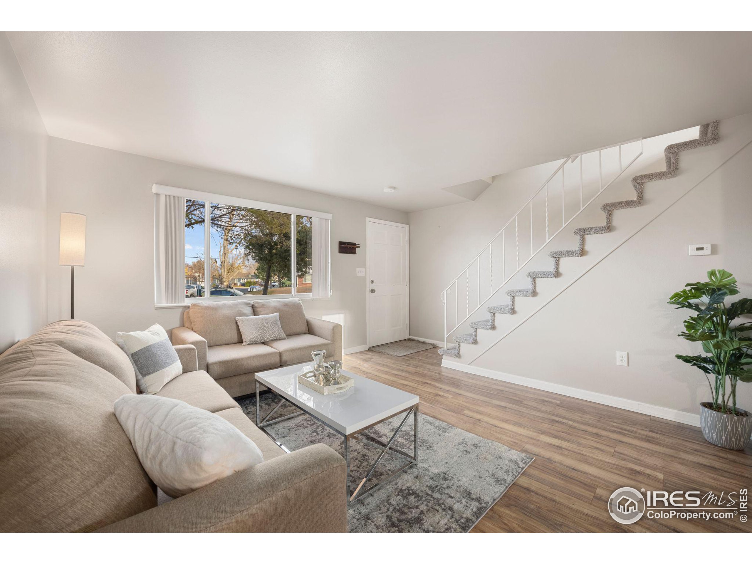 219 Chestnut Street Windsor, CO 80550 - Photo 11 of 23 a living room with furniture and wooden floor
