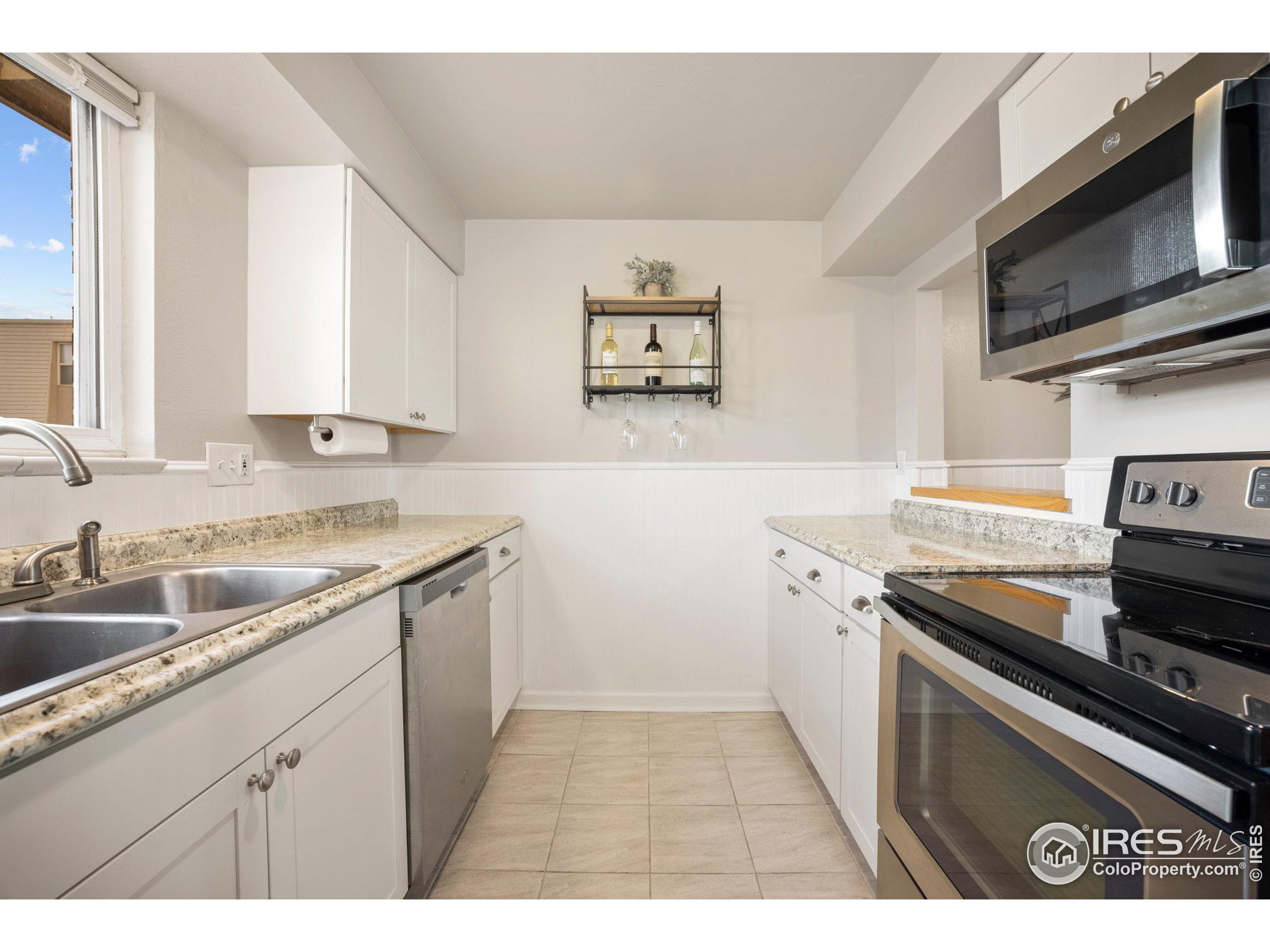 219 Chestnut Street Windsor, CO 80550 - Photo 12 of 23 a kitchen with a sink stove top oven and cabinets