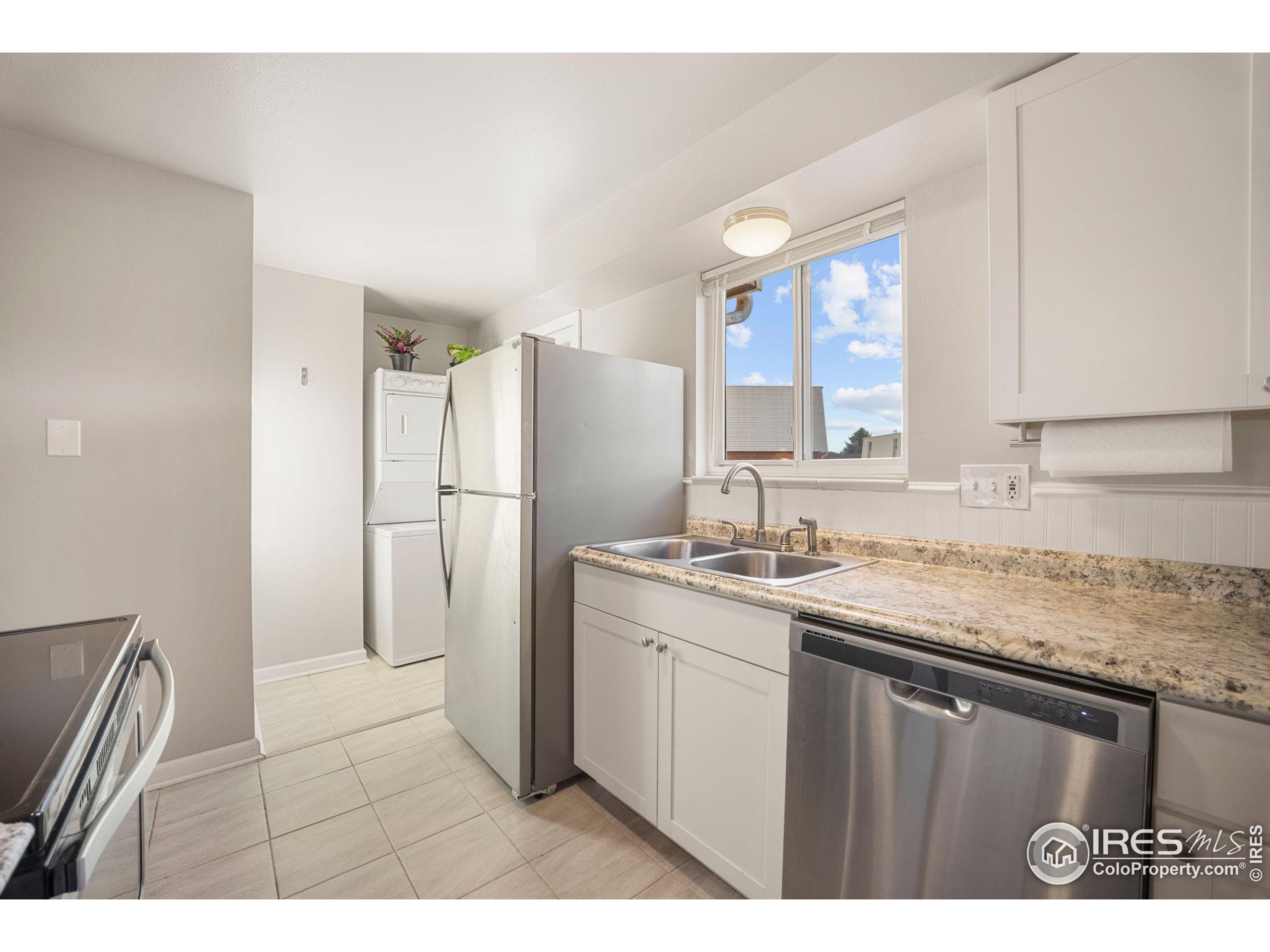 219 Chestnut Street Windsor, CO 80550 - Photo 13 of 23 a kitchen with a sink a refrigerator a stove a washer and dryer