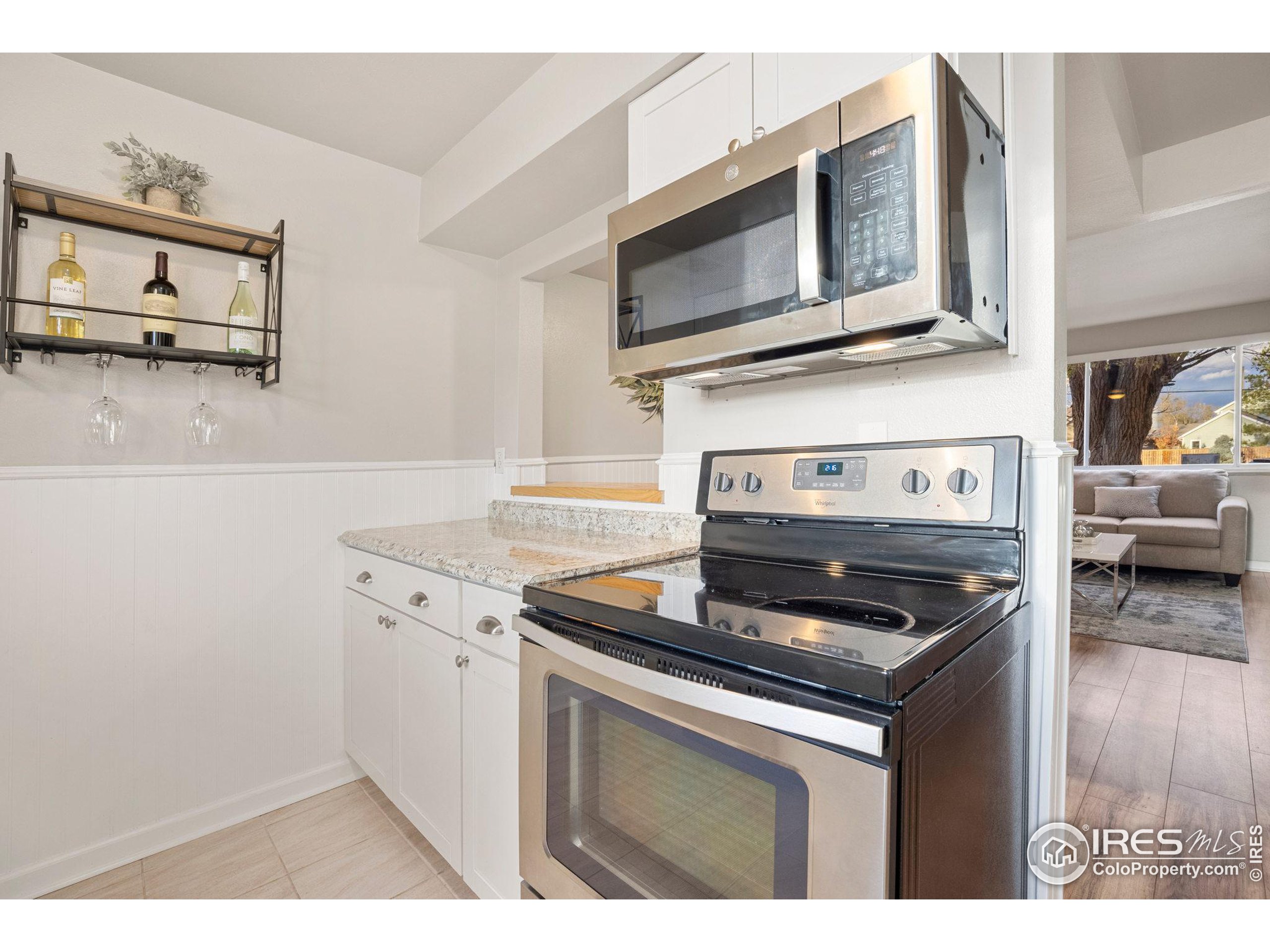 219 Chestnut Street Windsor, CO 80550 - Photo 14 of 23 a kitchen with stainless steel appliances granite countertop a stove microwave and sink