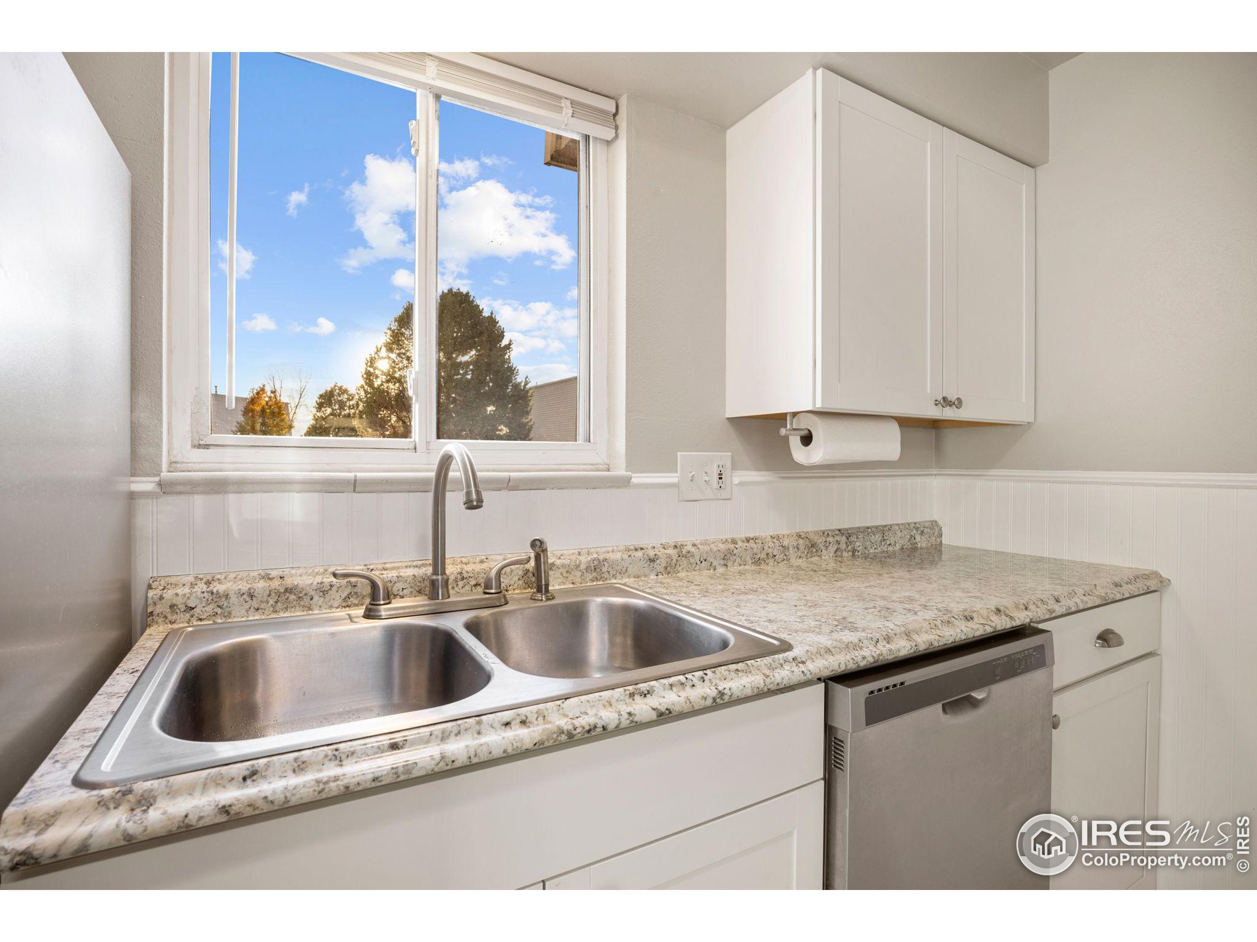 219 Chestnut Street Windsor, CO 80550 - Photo 15 of 23 a kitchen with a sink window and cabinets