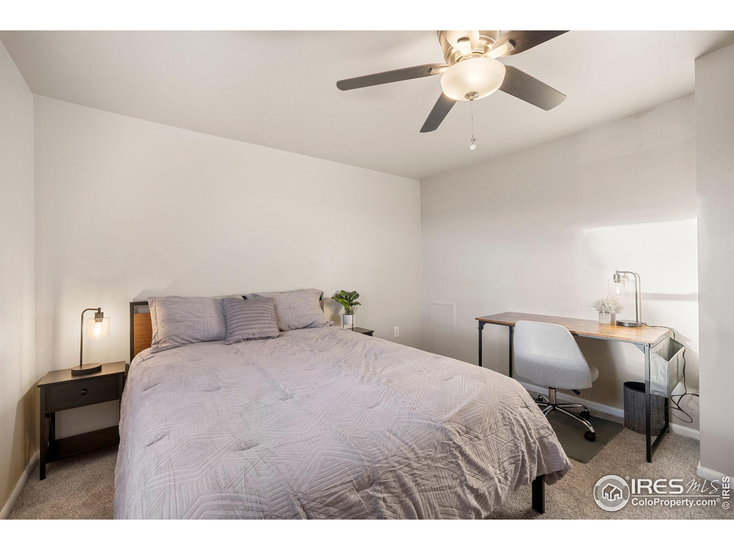 219 Chestnut Street Windsor, CO 80550 - Photo 20 of 23 a bedroom with a bed and a chandelier