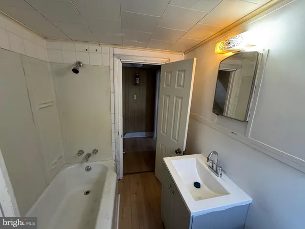 a bathroom with a tub sink and mirror