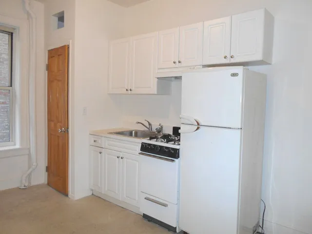 a kitchen with white cabinets and white appliances