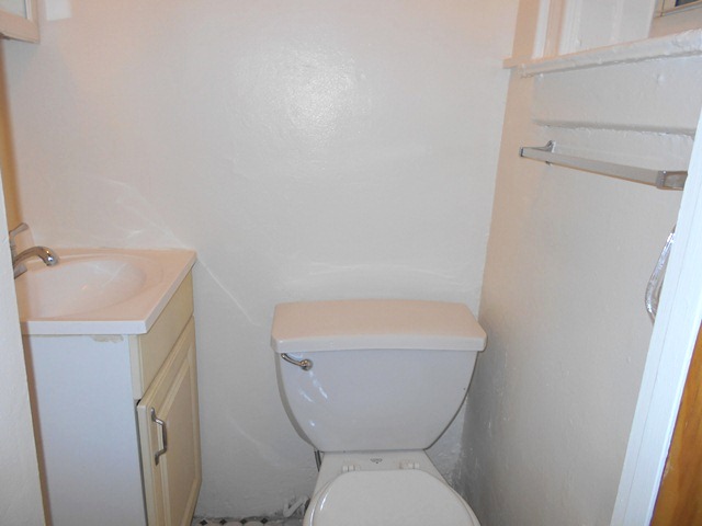170-172 Spring Street, Unit 7 Manhattan, NY 10012 - Photo 7 of 8 a white toilet sitting next to a small sink