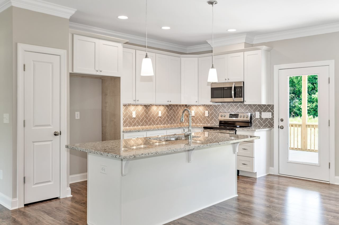 6733 Dwight Rowland Road Willow Spring, NC 27592 - Photo 6 of 25 Kitchen with herringbone back space and granite countertops central island with granite countertop over hang for dining or snacking kitchen