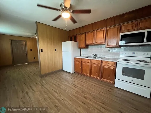 a kitchen with stainless steel appliances a stove top oven a sink and a refrigerator