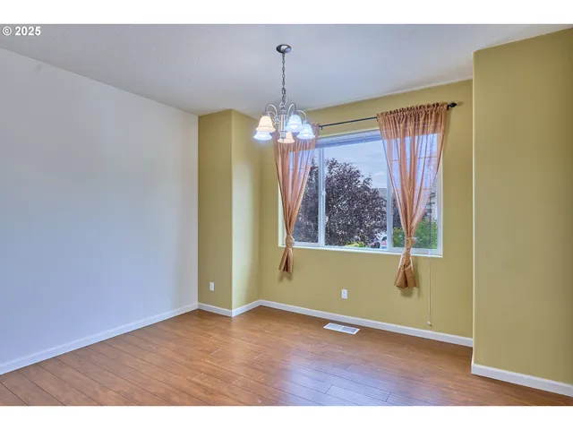 a view of a room with window wooden floor and chandelier