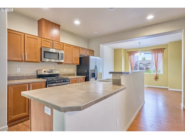 a kitchen with stainless steel appliances granite countertop a sink refrigerator and microwave