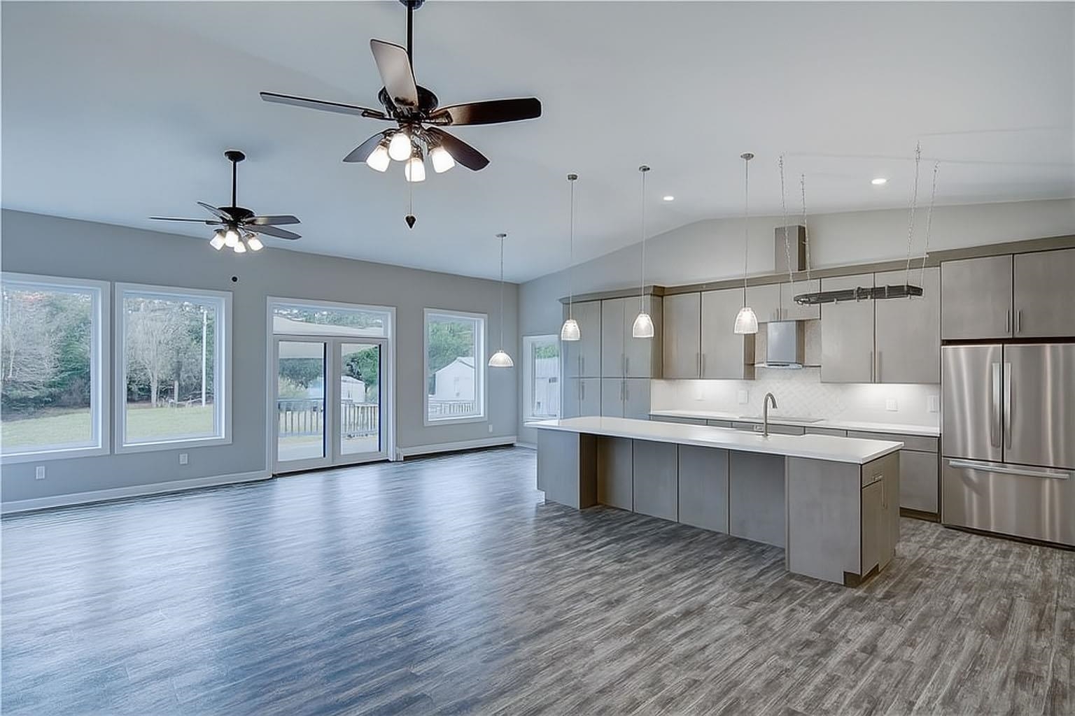 6030 Mitchell Road Iron River, WI 54847 - Photo 11 of 45 Kitchen with freestanding refrigerator, an island with sink, dark wood-style flooring, decorative backsplash, and lofted ceiling