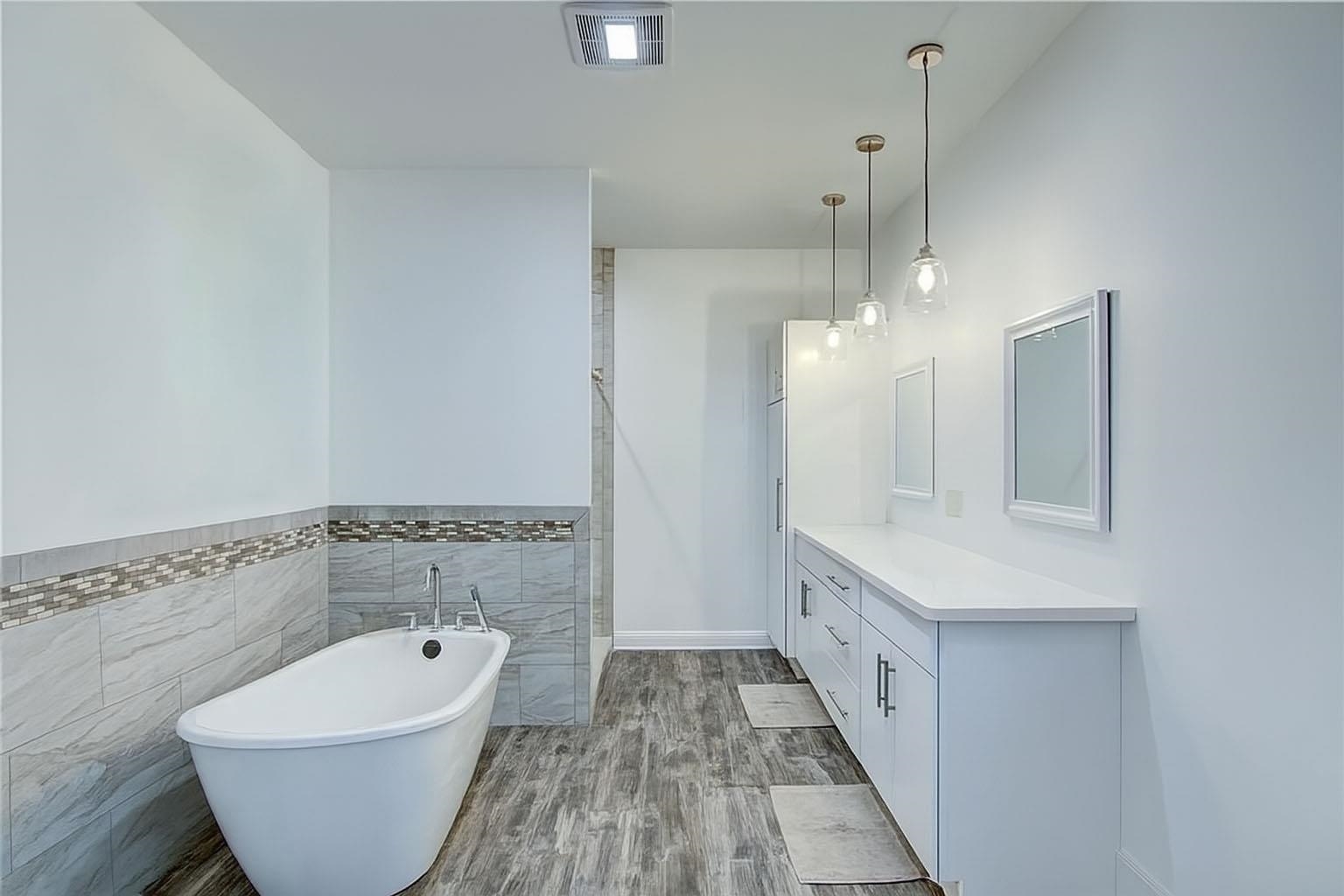 6030 Mitchell Road Iron River, WI 54847 - Photo 22 of 45 Bathroom with tile walls, vanity, a freestanding tub, wood finished floors, and a shower stall