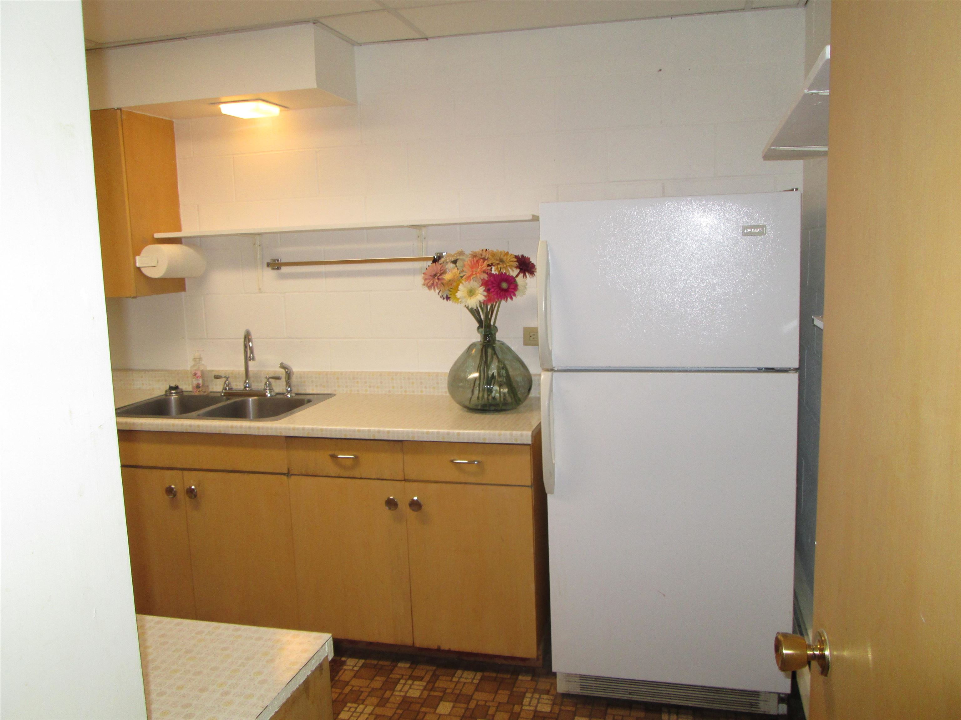 6030 Mitchell Road Iron River, WI 54847 - Photo 26 of 45 Kitchen featuring freestanding refrigerator, light countertops, backsplash, and brown cabinetry