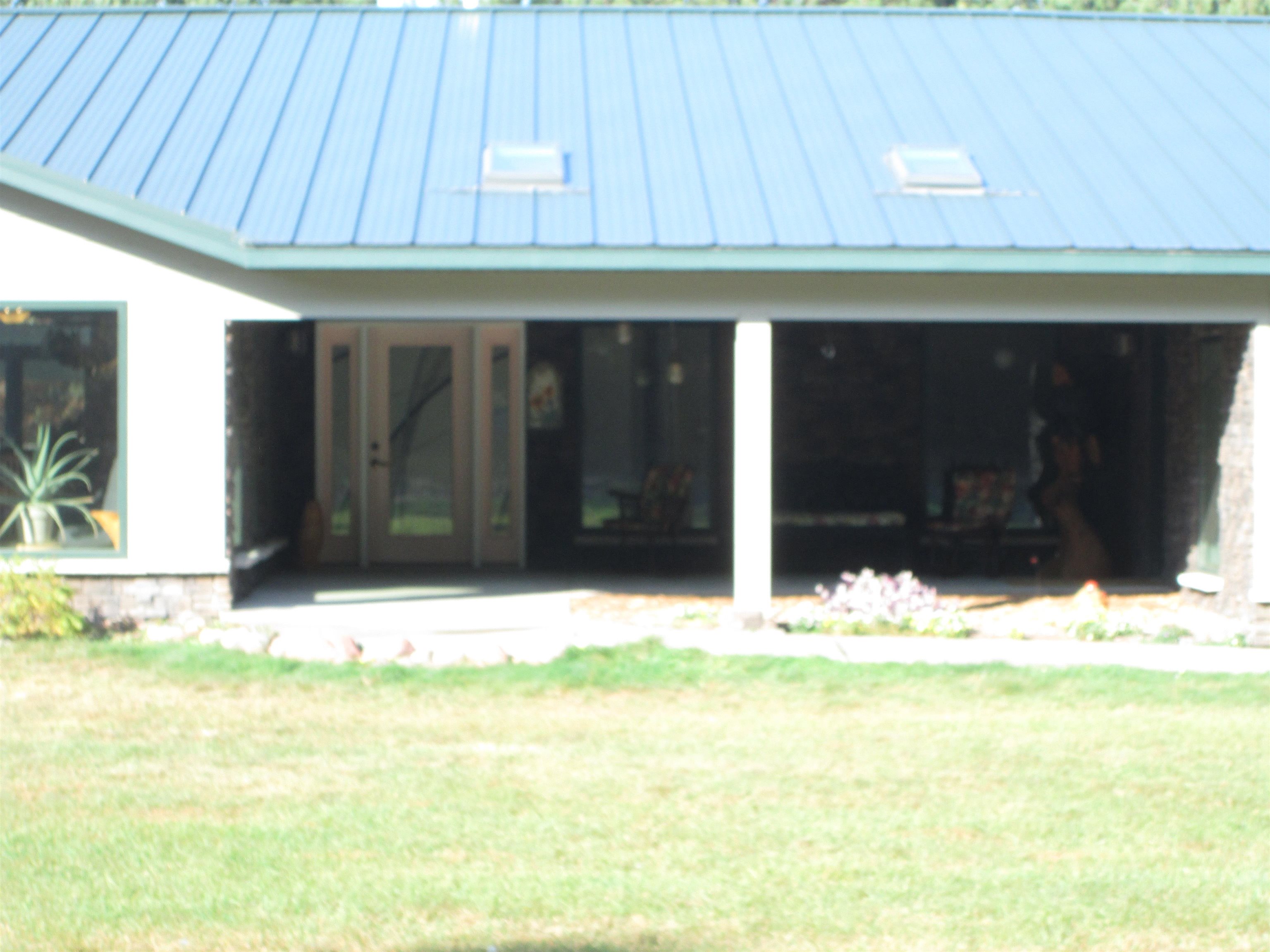 6030 Mitchell Road Iron River, WI 54847 - Photo 32 of 45 Back of house featuring a yard, a metal roof, and a porch