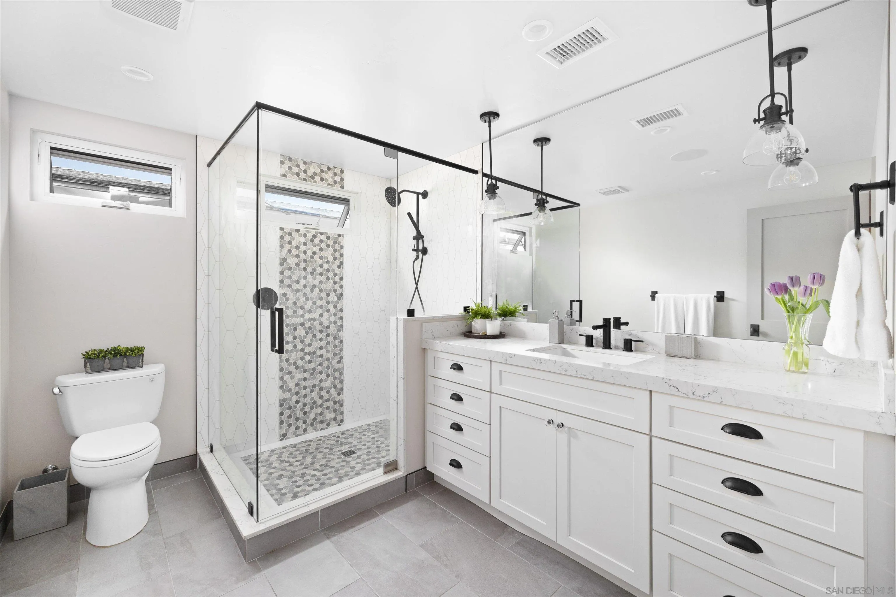 5351 Saxon Street San Diego, CA 92115 - Photo 16 of 34 a bathroom with a double vanity sink toilet and shower
